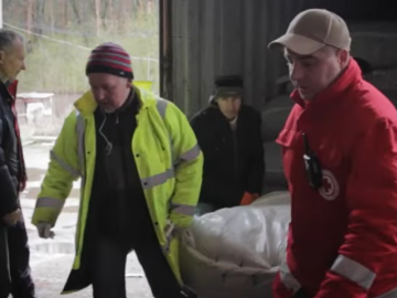 Men carrying delivery from humanitarian convoy in Chernihiv, Ukraine